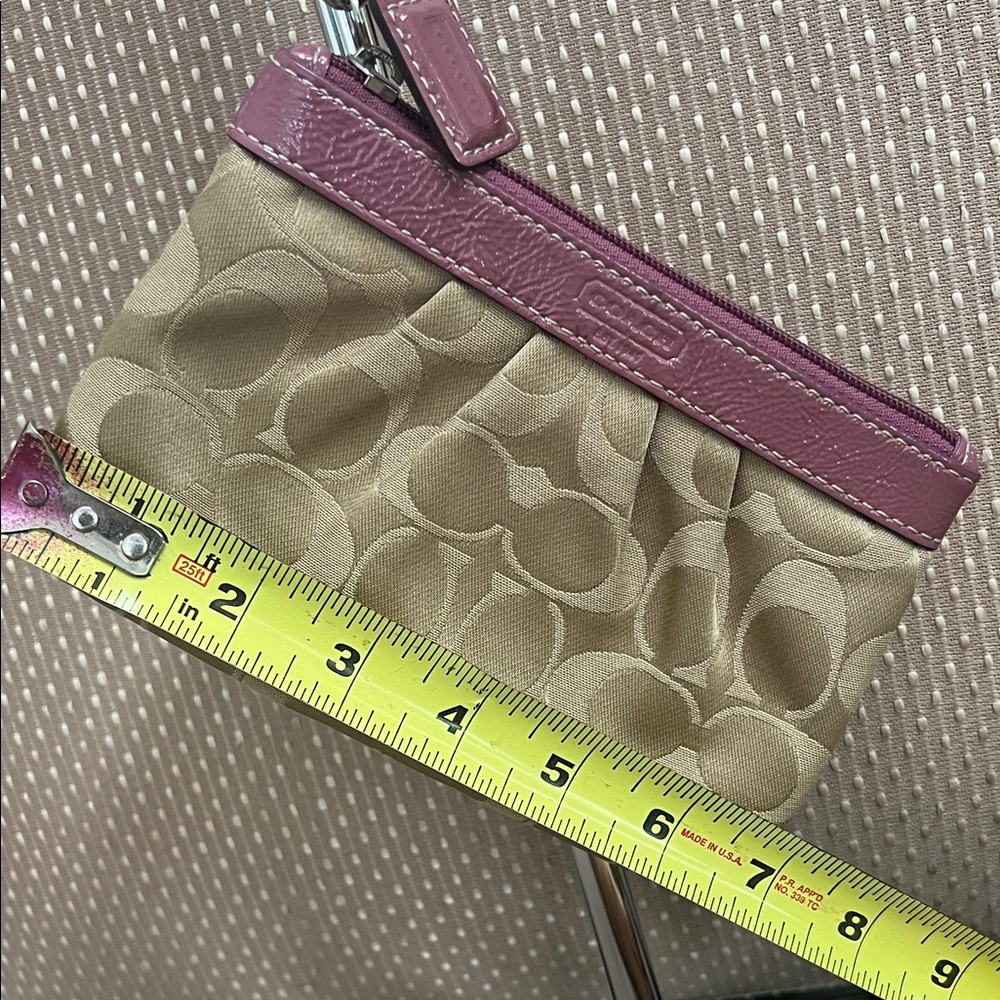 Coach tan signature wristlet with plum pink patent leather trim has hang tag